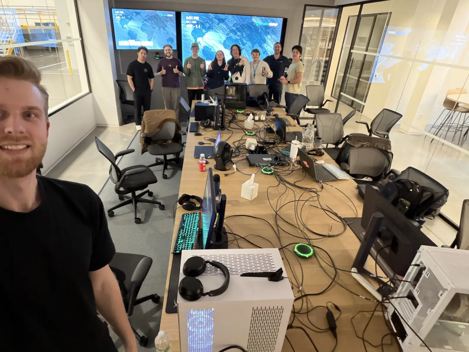 Team gathered around computers during a collaborative LAN and build session